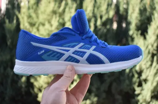 sepatu asics yang di genggam